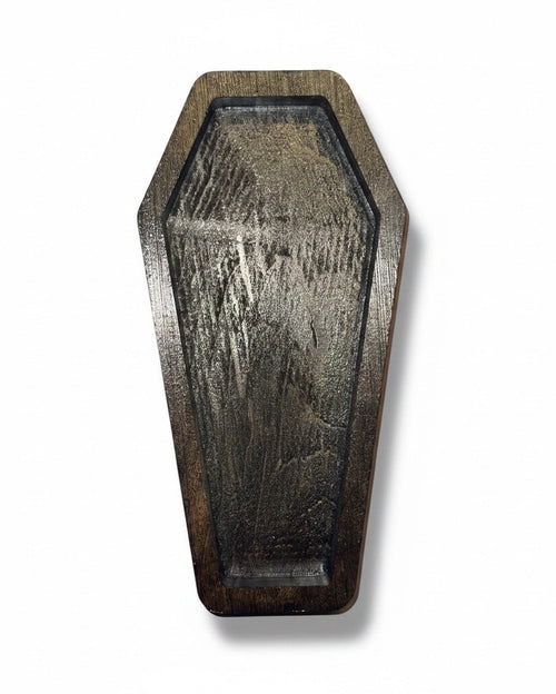 black coffin shaped ring dish on white background 