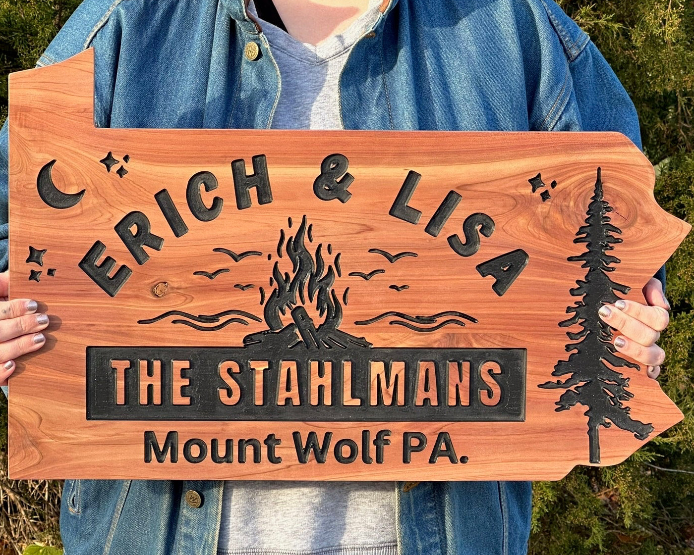 Custom house sign in the shape of Pennsylvania cut out on cedar with trees and stars and a moon. Families last name is in the center with a bonfire on top.