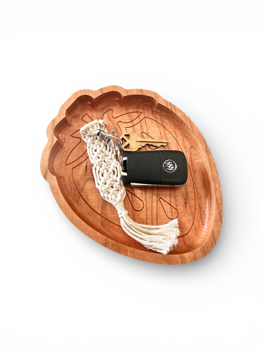 Wooden strawberrytray with a keychain and car key on a white background