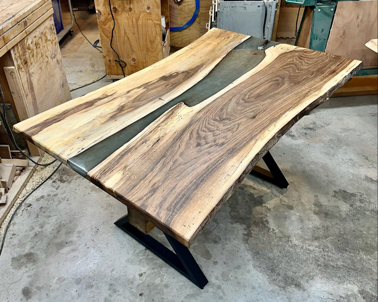 Wooden walnut table with live edge design and green resin river center