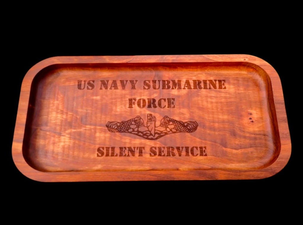 A rectangular wooden tray with rounded corners, featuring engraved text reading 'US NAVY SUBMARINE FORCE' and 'SILENT SERVICE' with a central emblem, shown against a solid black background.